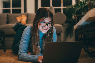 Portrait of young woman using laptop at table