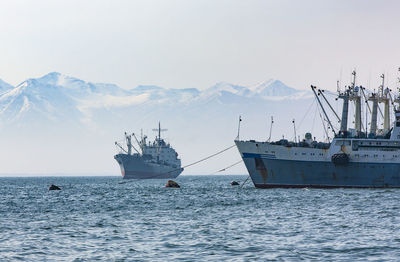 Large fishing vessel on the background of hills and volcanoes