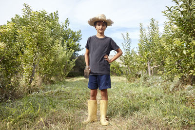 A boy in a straw hat who helps in the field with farm work.