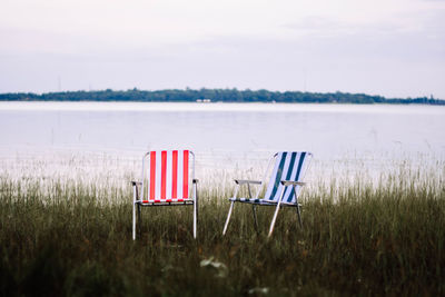 Chairs on beach against sky