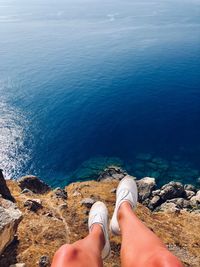 Low section of person on rock by sea