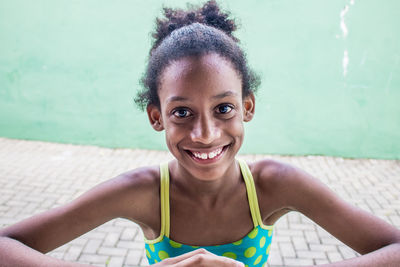 Portrait of smiling girl against wall