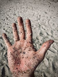 Close-up of hand on covered with sand