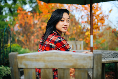 Portrait of woman sitting on chair outdoors