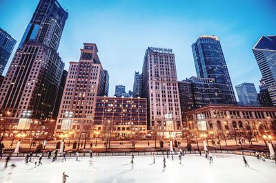 Modern buildings in city against sky during winter