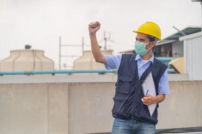 Portrait of man standing against wall