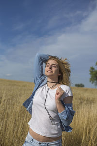 Smiling beautiful woman with eyes closed standing on field