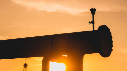 Low angle view of silhouette cross against sky during sunset