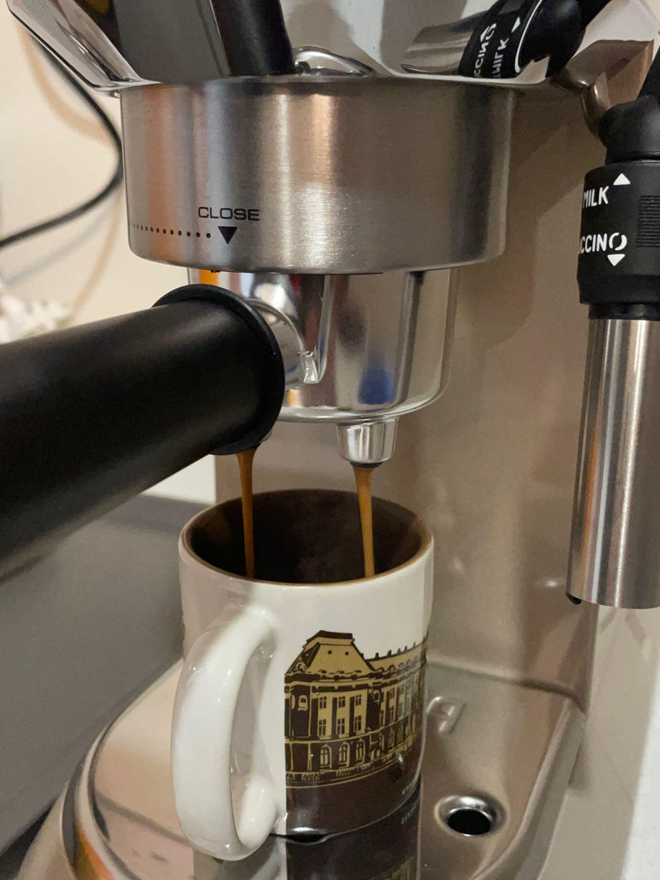 espresso machine, coffee, coffeemaker, espresso maker, food and drink, drink, small appliance, drip coffee maker, coffee cup, cup, indoors, pouring, mug, refreshment, home appliance, appliance, machinery, coffee shop, close-up, cafe, making
