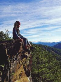 Low angle view of woman sitting on rock