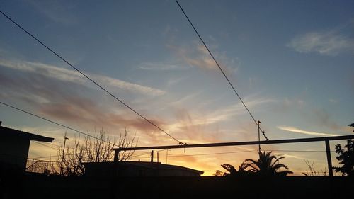 Low angle view of silhouette house against sky during sunset