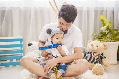 Father with cute son sitting at home