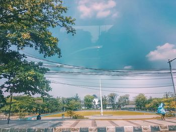 Road by trees against sky