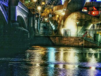 Illuminated bridge over river at night