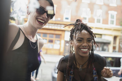 Two young women looking through a window and smiling.