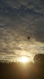 Silhouette hot air balloon against sky during sunset