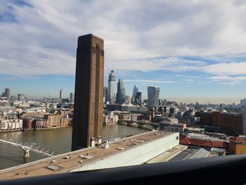 Modern buildings in city against cloudy sky