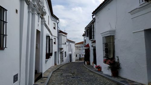 Narrow street amidst buildings against sky