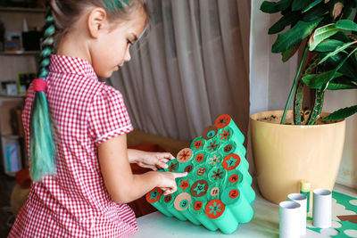Cute girl preparing christmas decoration at home
