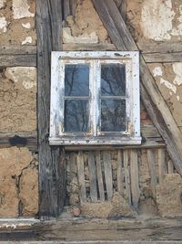 Low angle view of broken window of old building