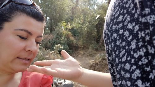 Portrait of woman with hands on tree