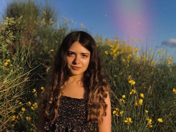 Portrait of young woman standing on field