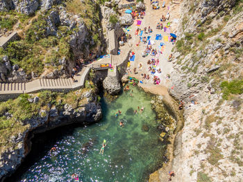 High angle view of stream amidst rocks and sea