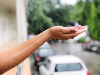 Cropped hand of woman outdoors during rainy season