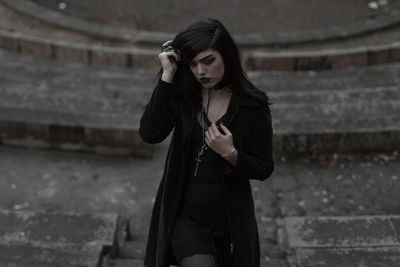 Young woman standing against abandoned building