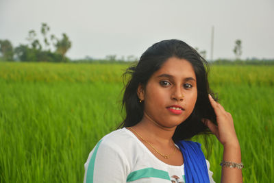 Portrait of beautiful young woman in field