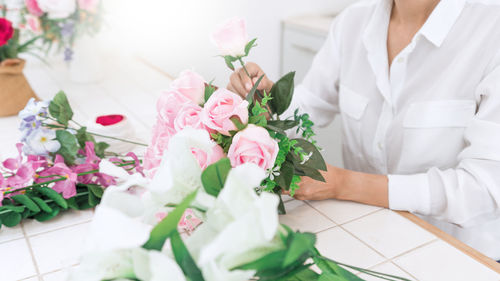 Midsection of florist making bouquet on table