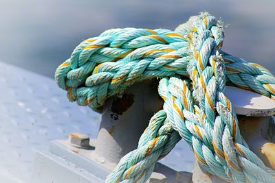 Close-up of rope tied to bollard at harbor