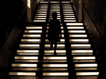 Rear view of person walking on staircase