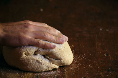 Cropped hand kneading dough