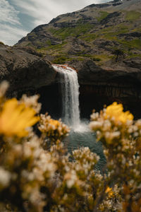 Scenic view of waterfall against sky