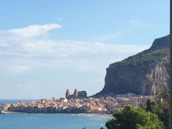 View of buildings by sea against sky