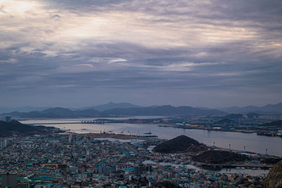 High angle view of townscape by sea against sky