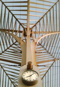 Low angle view of clock mounted against ceiling