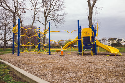 Playground in park against sky during winter