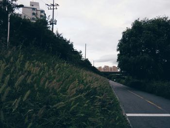 Empty road against cloudy sky