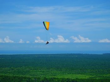 Scenic view of paragliding over sea against sky