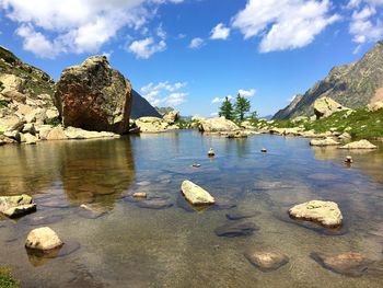 Rocks in lake against sky