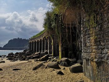 Panoramic shot of rocks on beach against sky