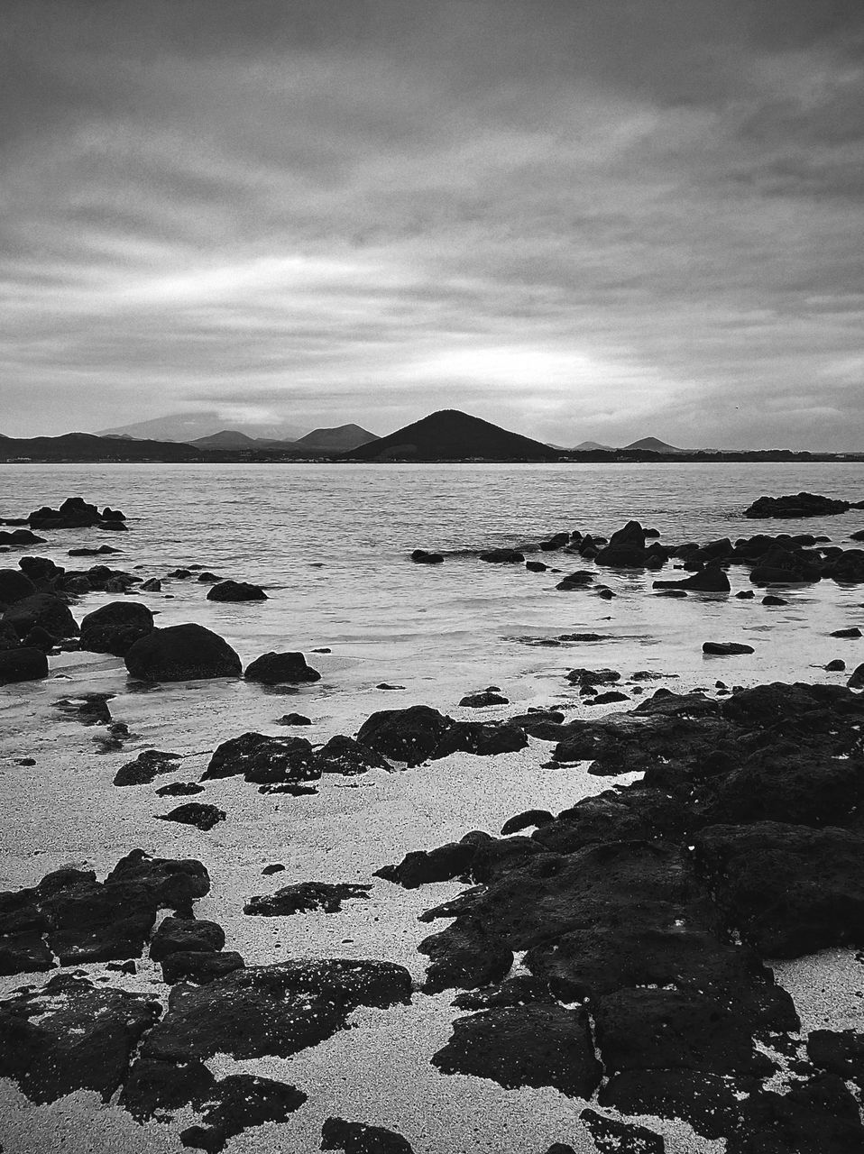 ROCKS ON BEACH AGAINST SKY