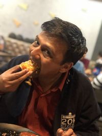 Portrait of man eating food in restaurant