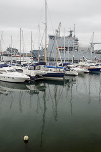 Sailboats moored at harbor