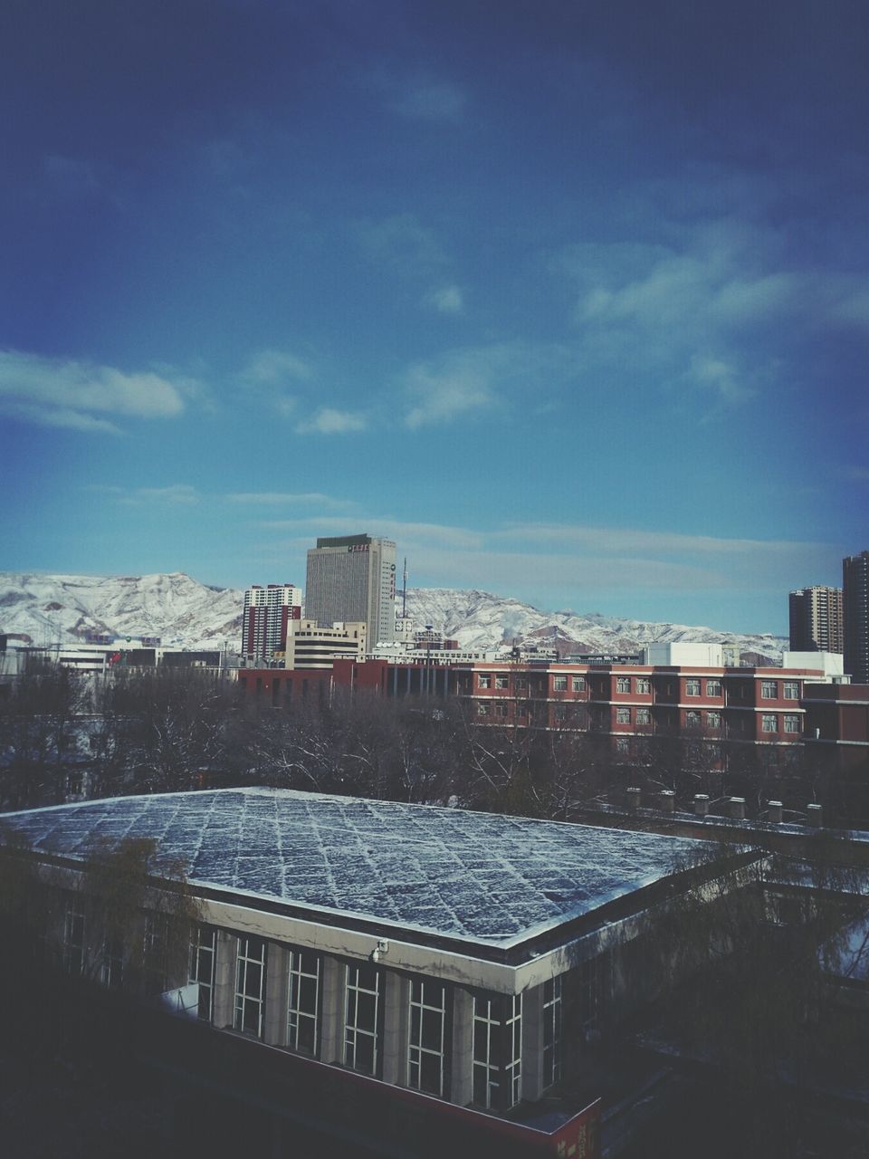 building exterior, architecture, built structure, city, snow, winter, sky, cold temperature, cityscape, residential building, season, residential structure, cloud - sky, weather, building, residential district, blue, tower, day, skyscraper