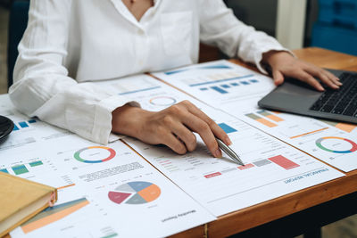 Midsection of business colleagues working on table