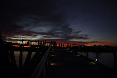 Pier over sea against sky during sunset