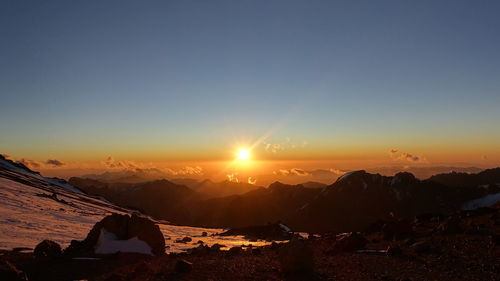 Scenic view of snowcapped mountains against sky during sunset